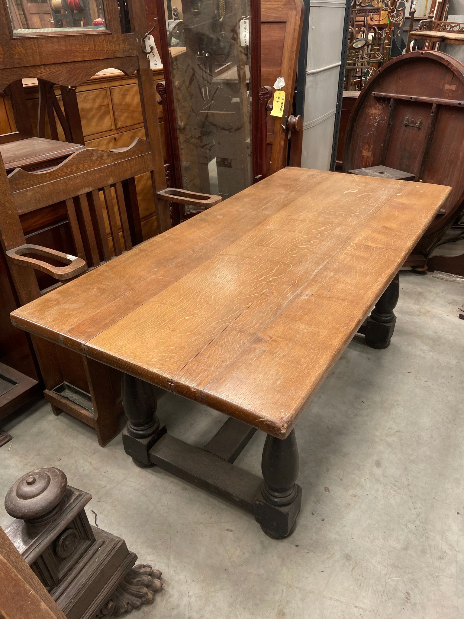 Long solid oak refectory dining table with dark wooden legs and a golden oak top.&nbsp;