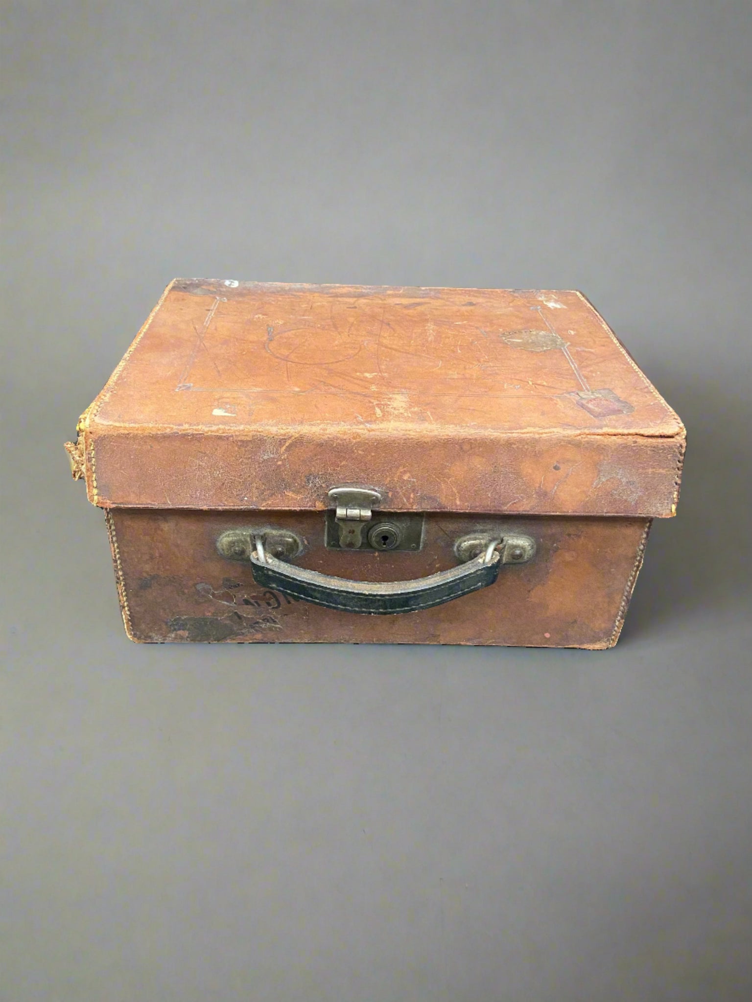 Small square brown leather case with a lockable lid.