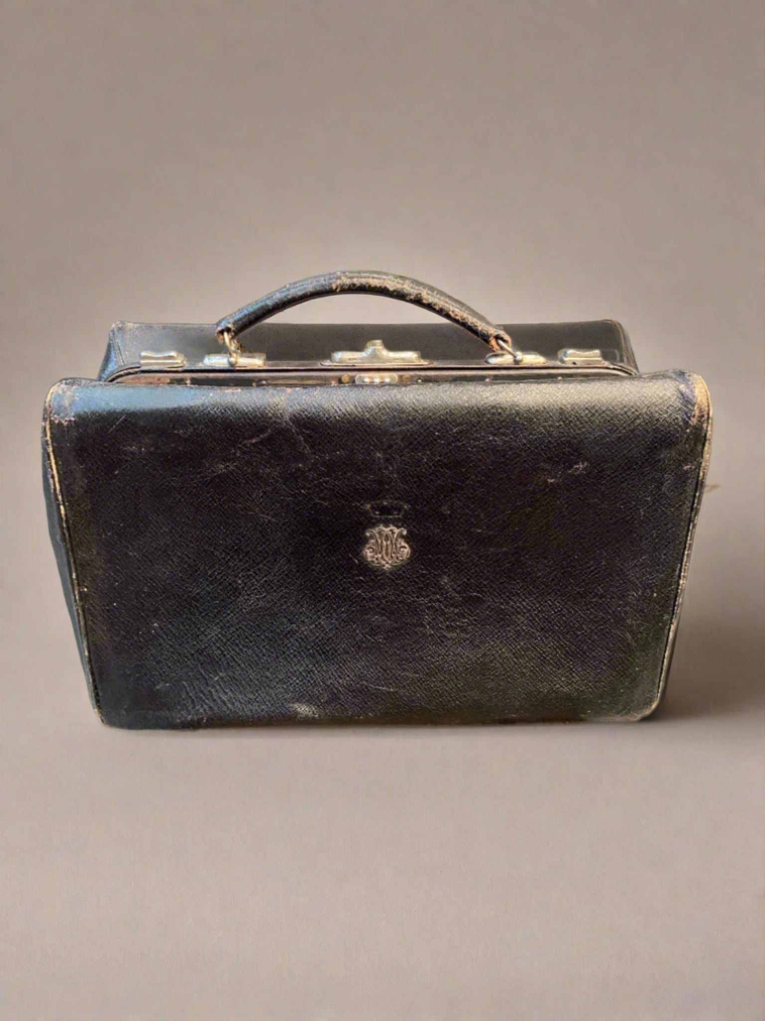 Vintage black leather doctor's bag monogrammed with ornate silver metal initials.&nbsp;