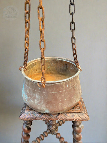 Hanging fireside cooking pot/cauldron on chains.