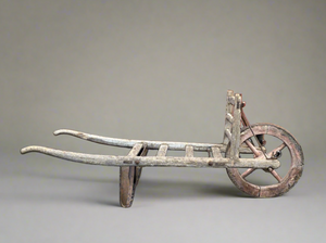 An antique aged wooden wheelbarrow, with a plain, stainless finish.