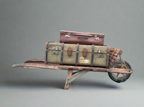 Brown wooden barrow cart, dressed with luggage.