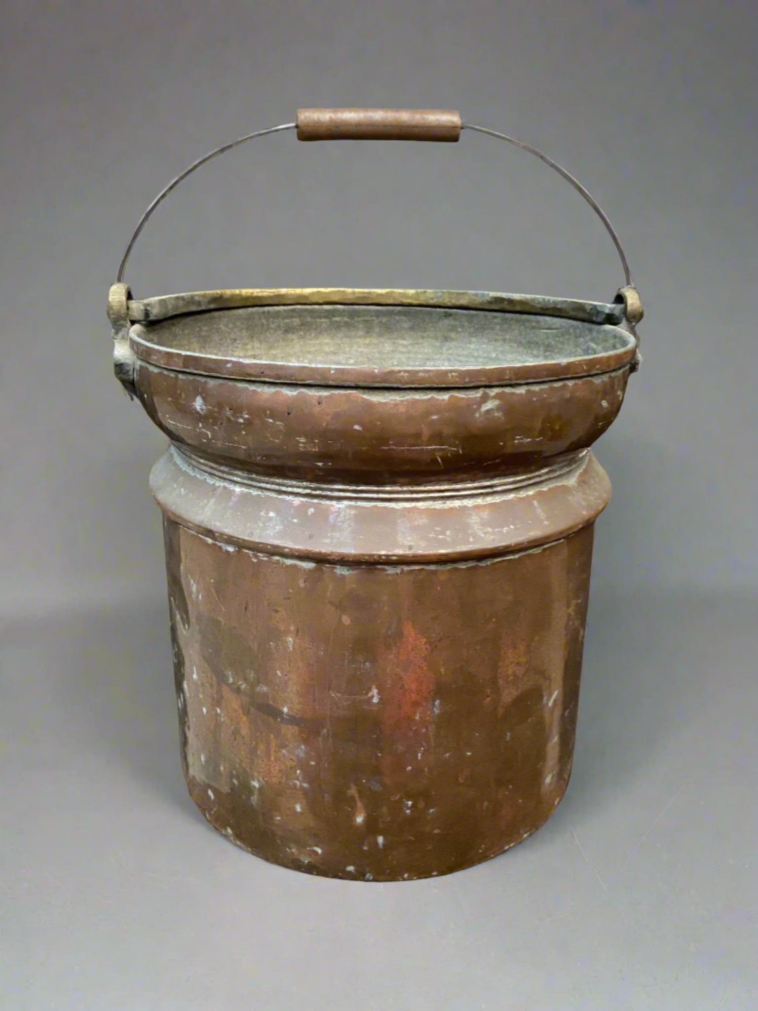 Persian or Ottoman copper pail with a thick gold handle and smooth body.