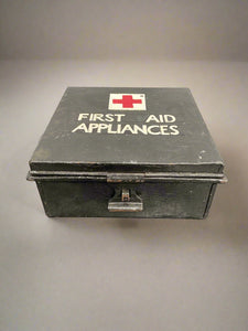 Vintage black metal first aid box, filled with first aid dressings.