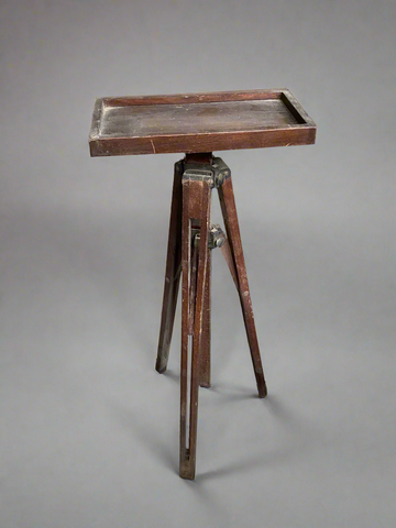 Dark wooden tripod with a rectangular tray top in an aged condition.