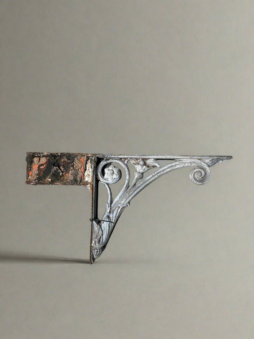 Victorian white iron bracket with a floral and scroll motif.