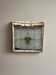 Antique window with a rusty white frame and a stained glass centre.