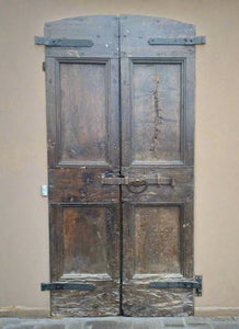 Rustic double door, built in a Spanish style, with a large bolt latch.