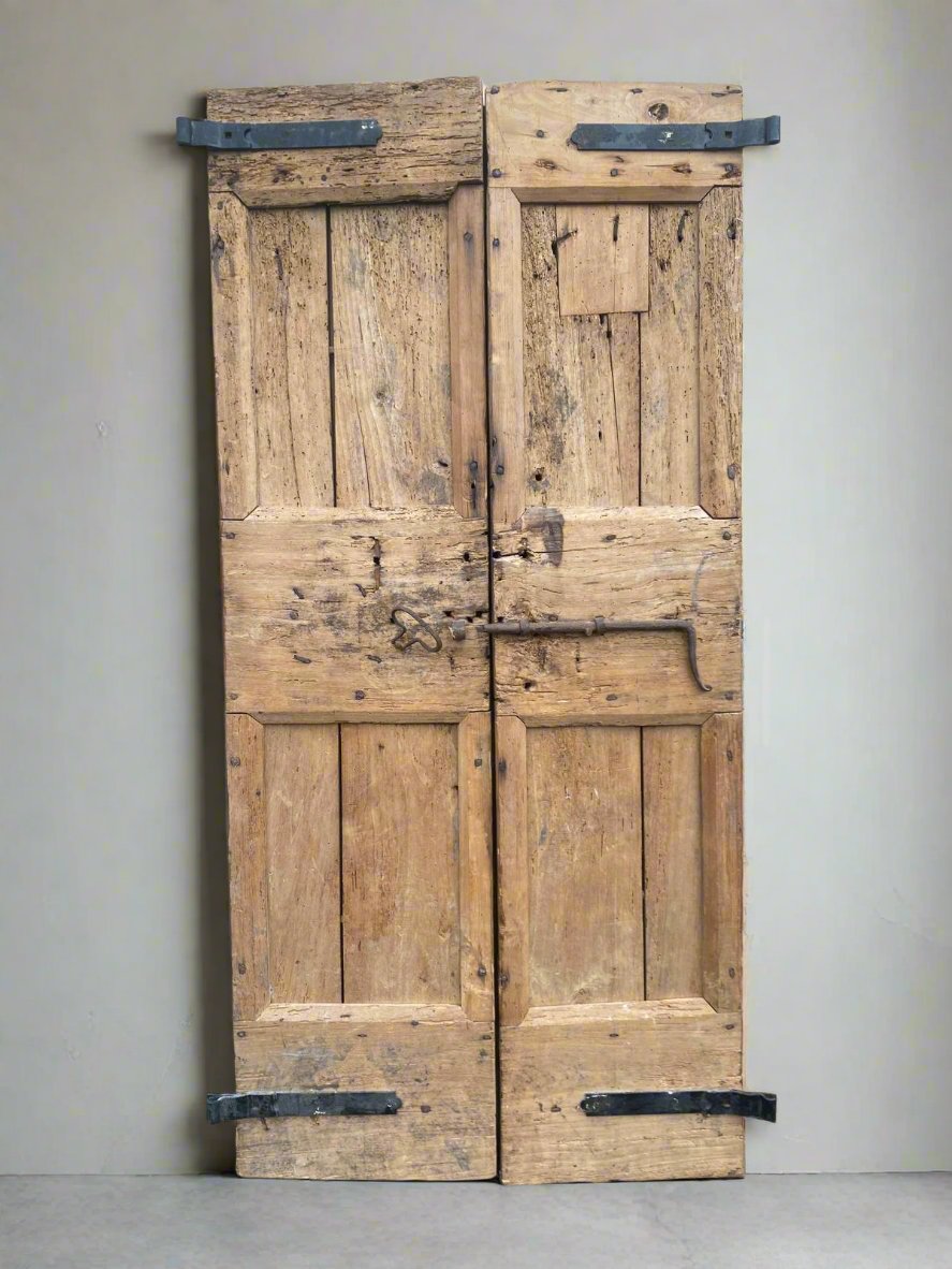 Aged double doors crafted from natural, unvarnished wood.