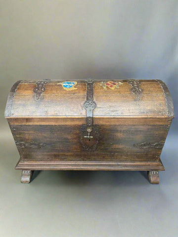 Large domed top chest with decorative strap work and wooden feet. May have once been a marriage chest/ wedding trunk.