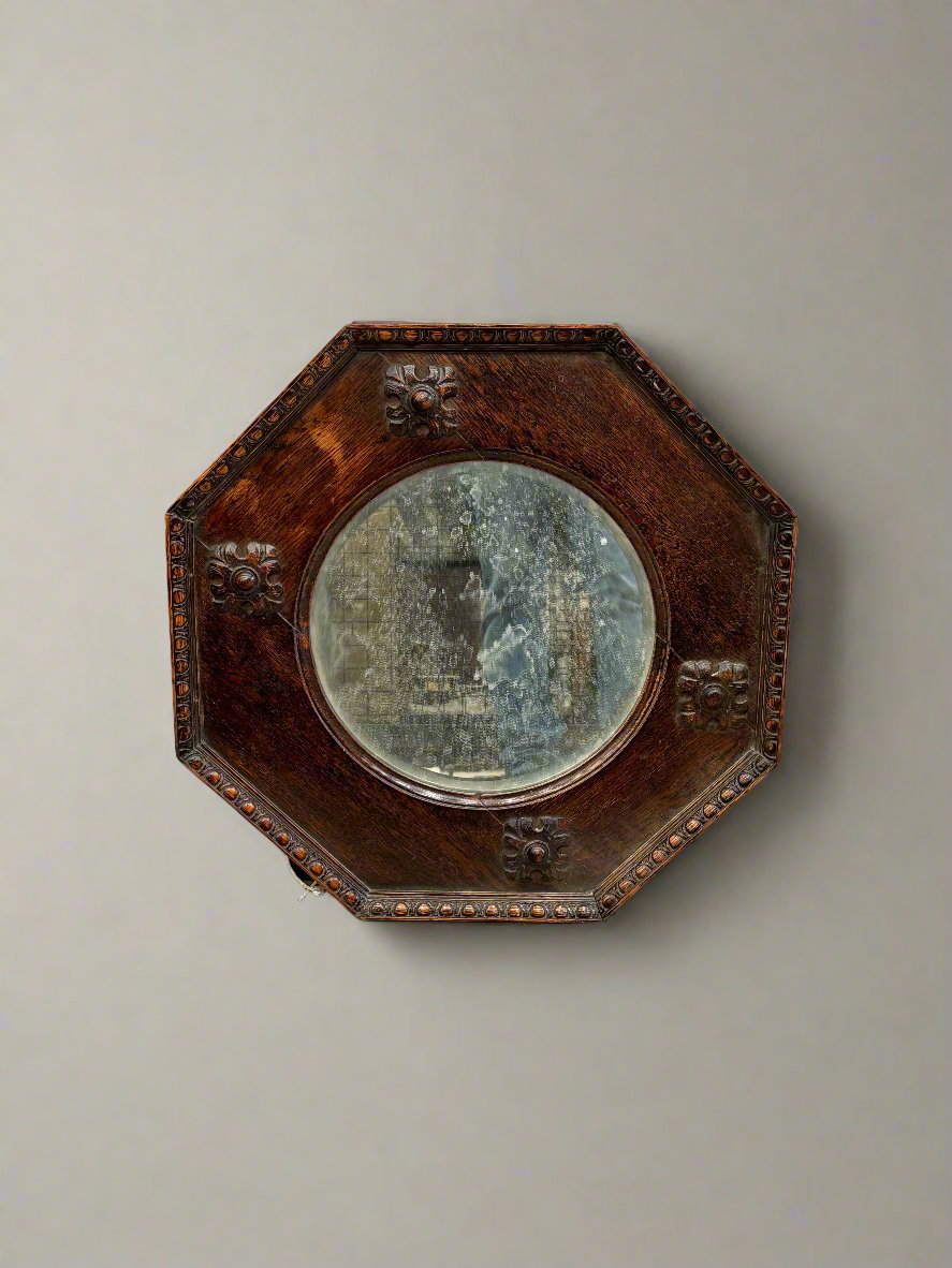 Arts & Crafts antique octagonal mirror with carved detailing.