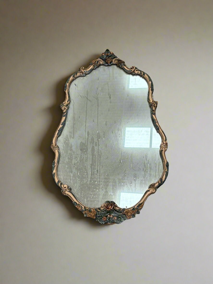 Ornate gilt wall mirror with an unusual green and gold frame.