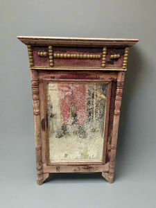 Distressed pink painted wooden mirror decorated with small golden balls.