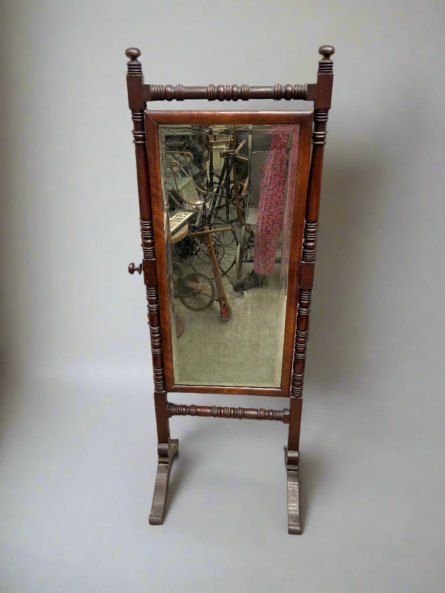 English regency cheval mirror with a turned mahogany frame and swing mirror. Circa early 1800s.