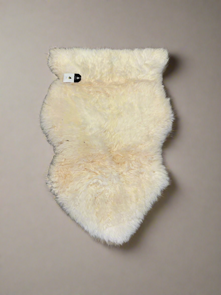 A pair of cream sheepskin rugs.