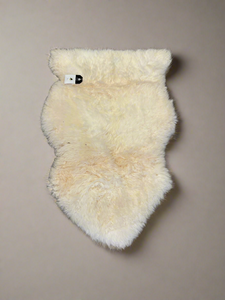 A pair of cream sheepskin rugs.