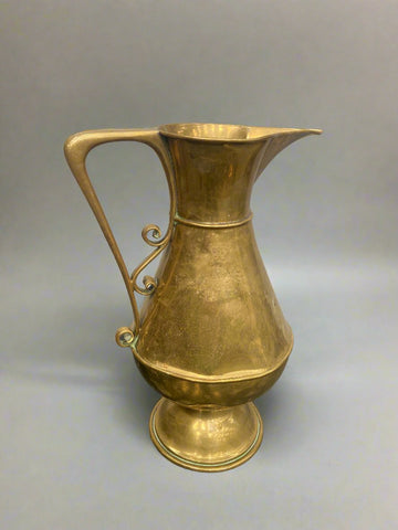 Middle Eastern brass pitcher with an elegant scroll handle.