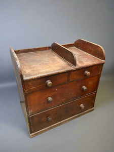 A simple aged Victorian chest of drawer with four drawers and a sectioned top.