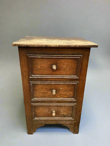 Aged wooden bedside drawer with a simple construction.