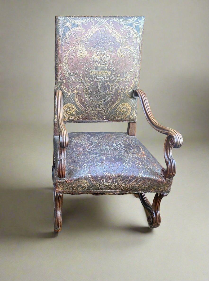 A pair of French 19th century armchairs upholstered with ornate brown and gold leather fabric.