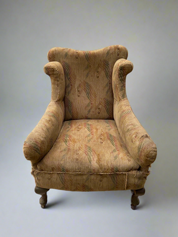 Antique Victorian beige patterned wingback chair with cambriole legs on castors.