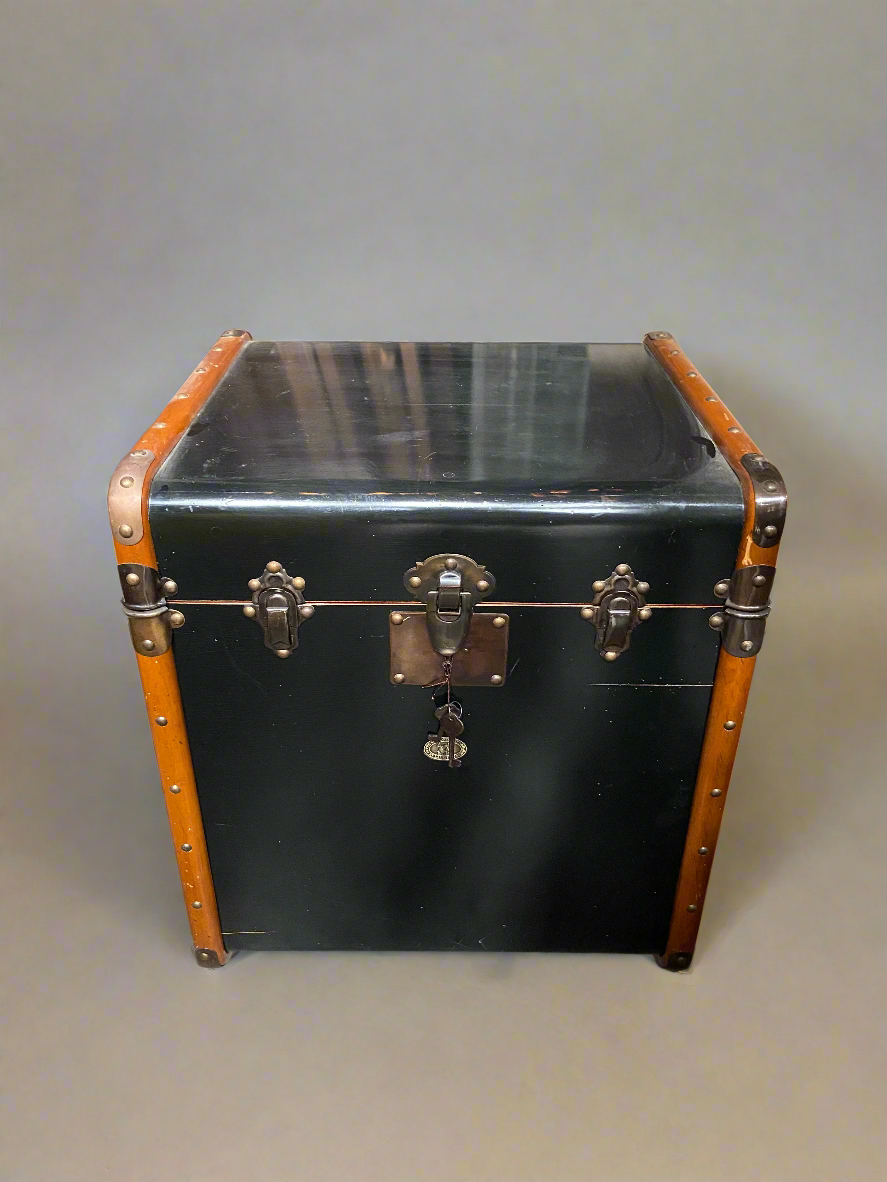 A set of black stateroom trunk/end tables in a Victorian style. The tall, square shape of the trunk was designed to fit easily into tight cabins during extensive travel.