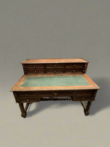 Antique wooden writing desk with barley twist legs and a green top.