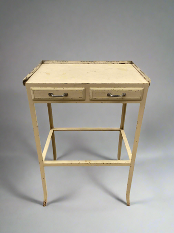 Industrial metal side table to hold medical instruments, painted with pastel yellow paint.