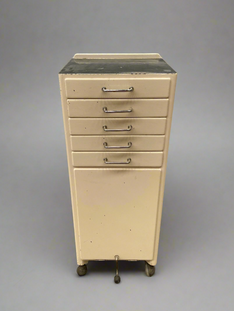 Vintage cream dental cabinet with shallow drawers and ageing.