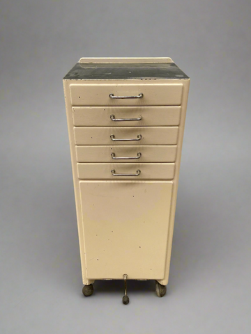 Vintage cream dental cabinet with shallow drawers and ageing.