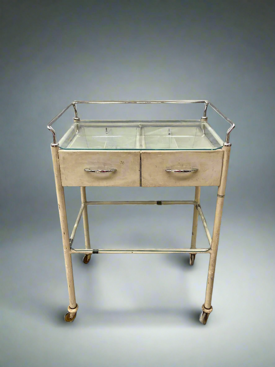 Cream medical trolley with a glass top, on wheels for ease of movement. Ideal hospital ward or dental surgery dressing.