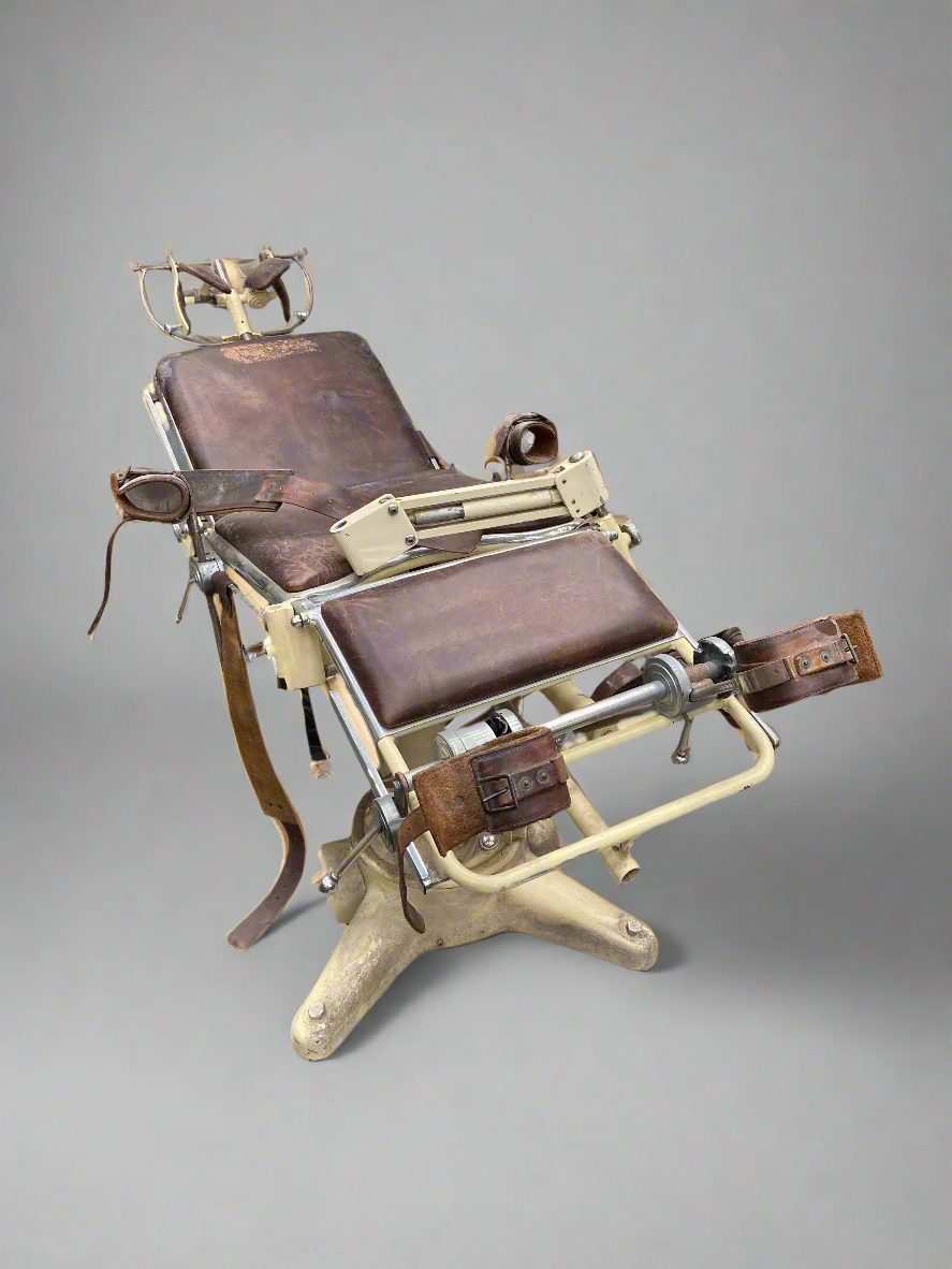Vintage medical bed/reclining chair with leather restraining straps.