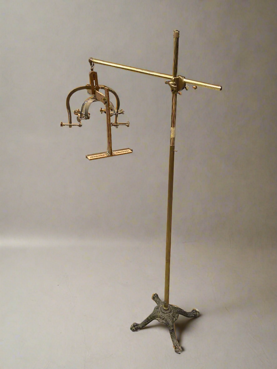 Medical/ torture brass head clamp on a cast iron stand. The wooden rulers prompt medical purposes, i.e. measuring a patient's head, however the brass screws could have been used for torture.