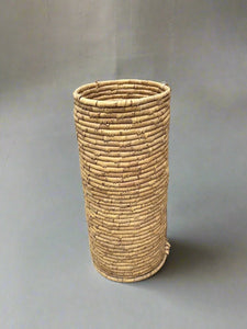 Woven rattan round umbrella holder.