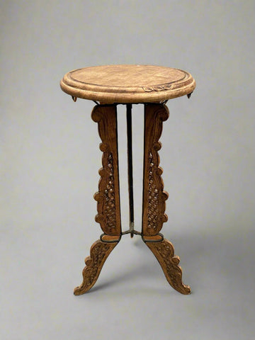 A matching pair of heavily carved tripod Indian tables/ plant stands/ jardinieres.