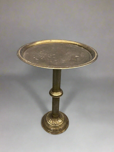 Round brass tea table with an etched ornate symmetrical design.