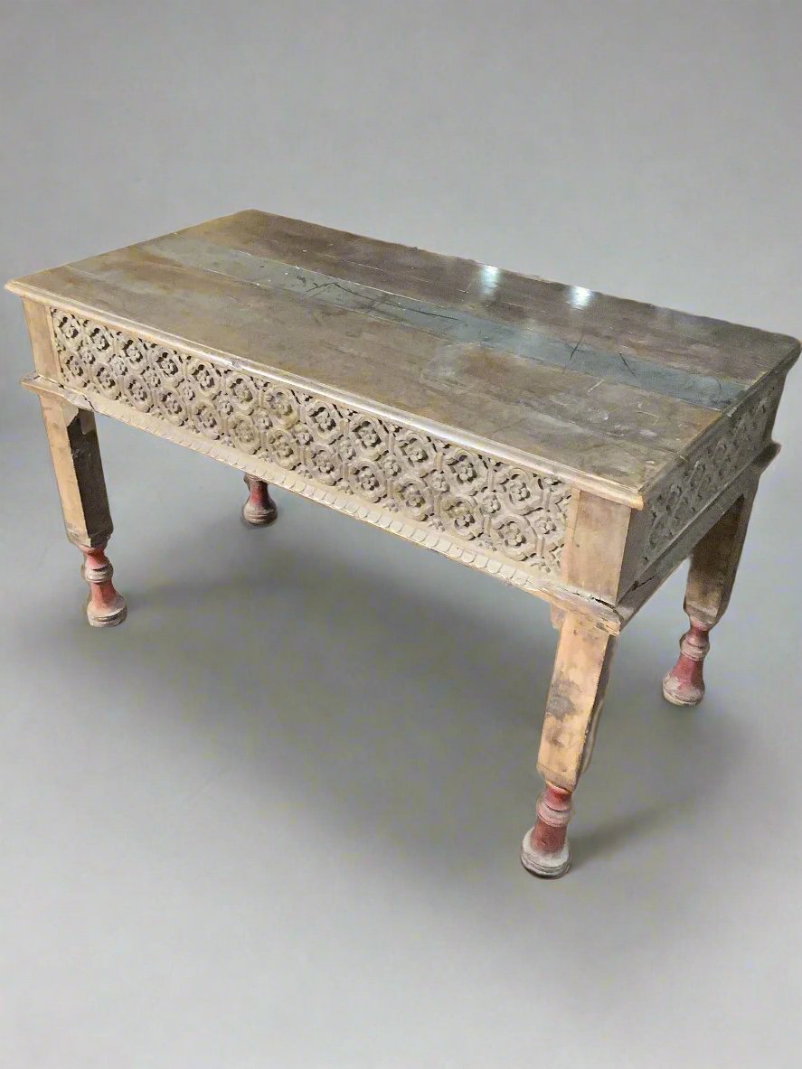 Indian wooden side table with an ornate carved edge and painted red feet.