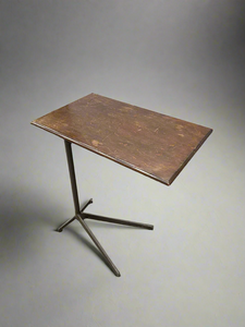 Industrial stand-over-bed table with a wooden top and cast iron legs.