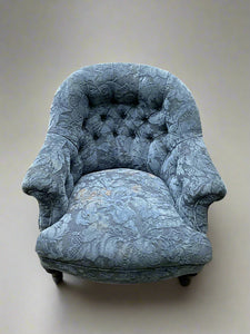 Victorian buttoned armchair upholstered with floral blue damask fabric.