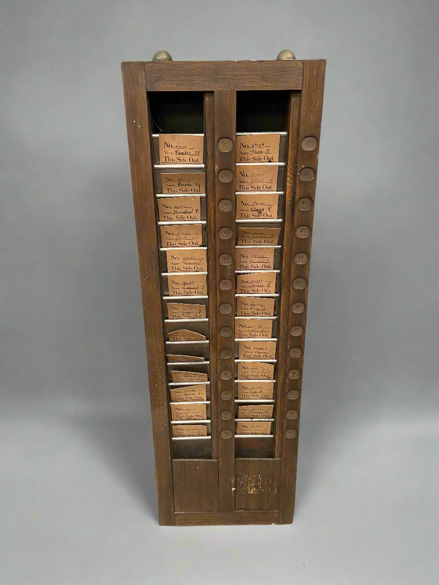 A pair of antique, wooden, clocking-in-card racks, circa early 20th century. Dressed with employee cards.
