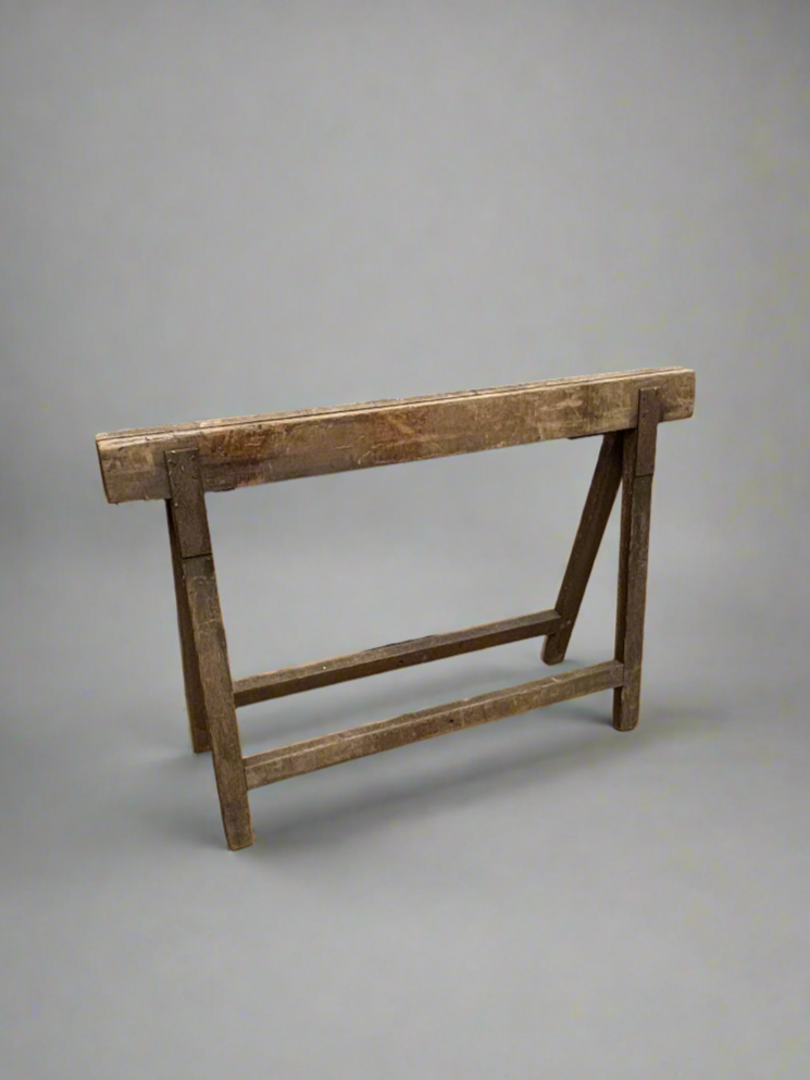 Wide wooden trestle stand in an aged condition.