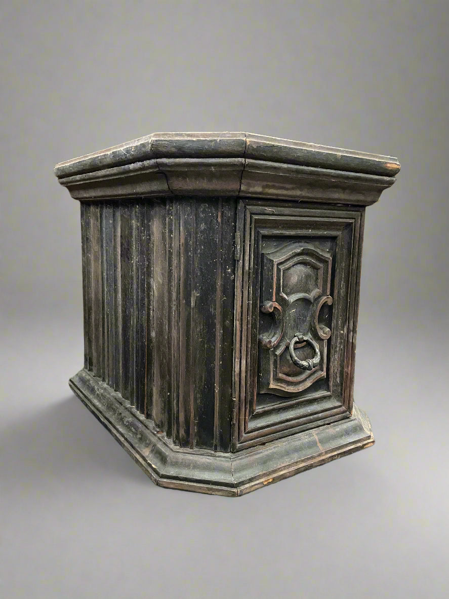 A pair of unusual antique wooden plinth tables with hidden storage. The front face features a carved design and ring pull handle.