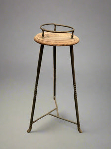 Unusual, industrial-style plant stand with a brass barrier and twisted metal legs.