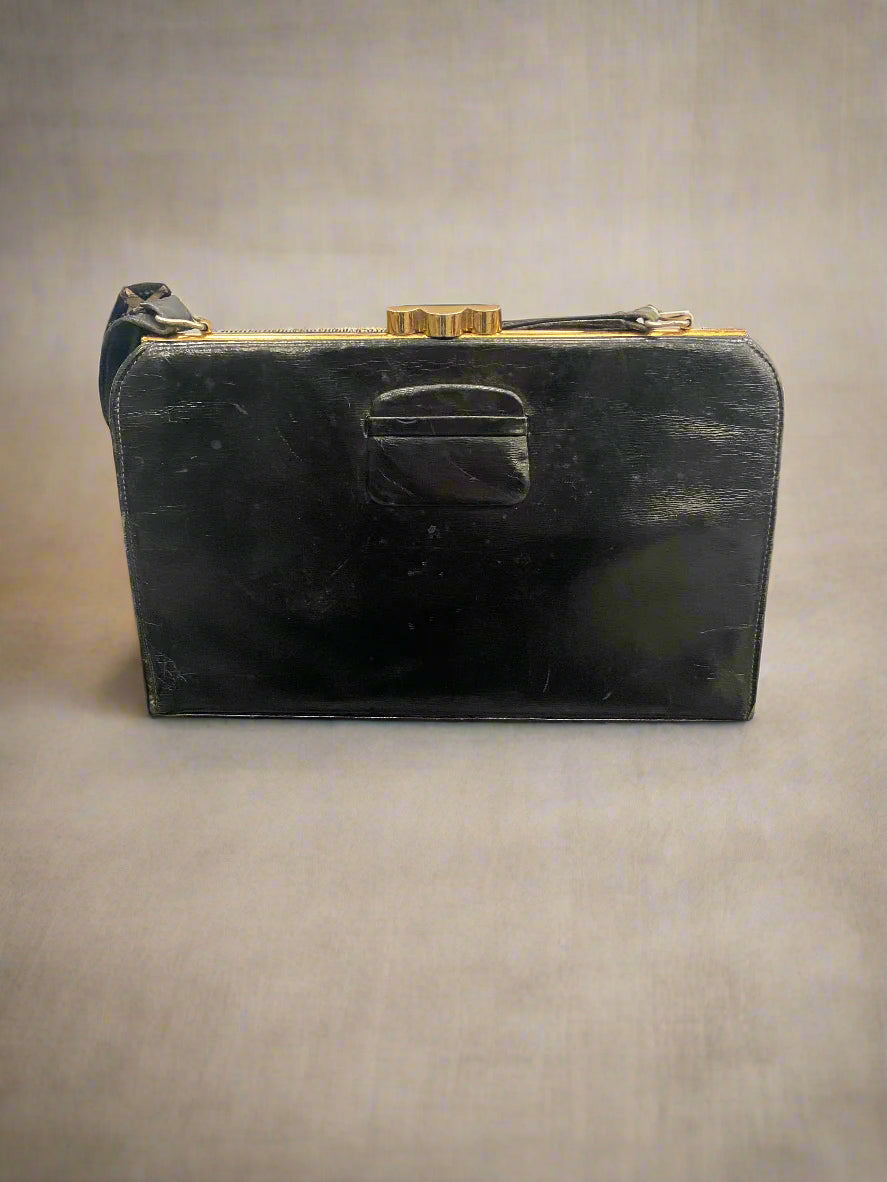 Vintage black leather handbag with a brass clasp.
