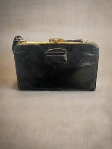 Vintage black leather handbag with a brass clasp.