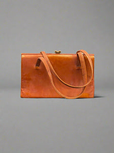 Vintage orange leather handbag with a brass clasp.