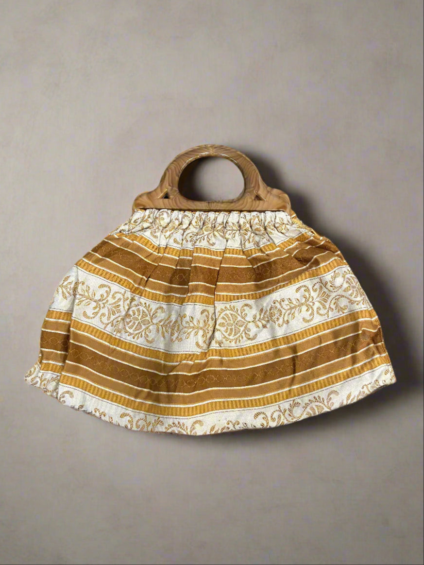 Vintage bag with a brown, mustard and white pattern fabric and wooden handle.