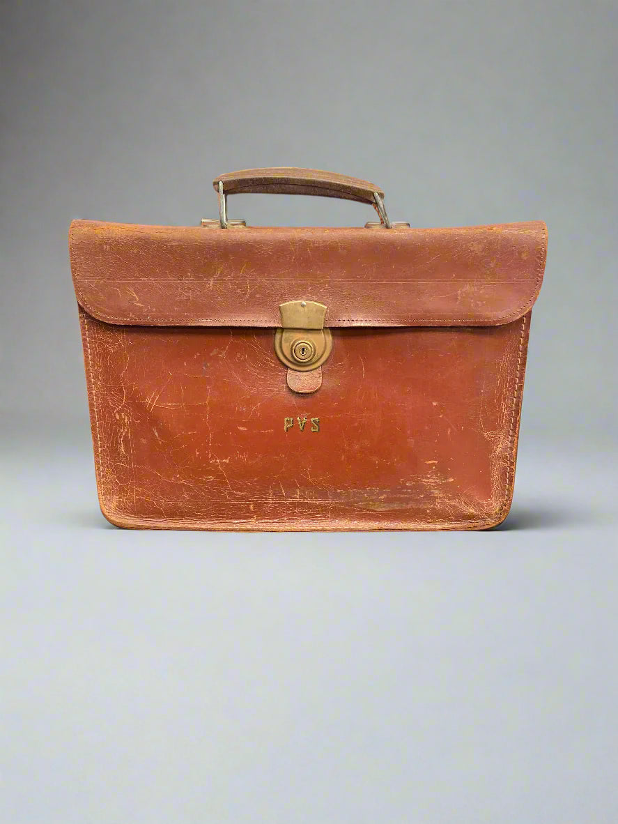 Orange brown leather briefcase initialled with the letters PVS.