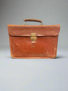 Orange brown leather briefcase initialled with the letters PVS.