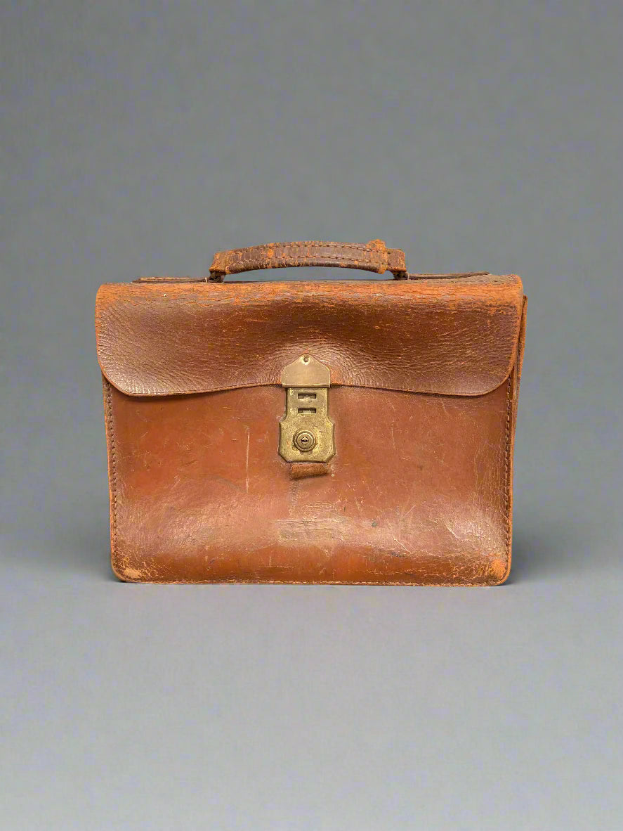 Classic brown leather briefcase with a brass lock, in an aged condition.